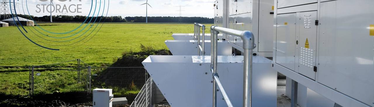 Tussen de windmolens in Lelystad staan twee grote batterijen voor de opslag van duurzame energie.